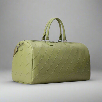 Green quilted duffel bag on a white background