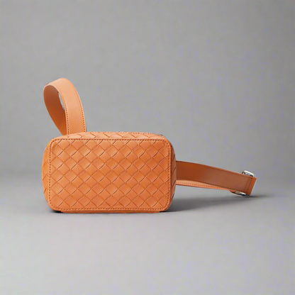 Brown woven leather bag with a strap on a white background